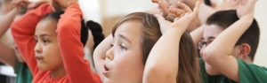 Kinder halten ihre Hände über den Kopf.