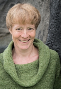 Eine Frau blickt lächelnd in die Kamera.