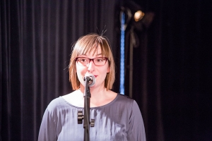 Eine Frau steht am Mikrofon.