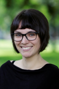 Eine Frau blickt lächelnd in die Kamera.