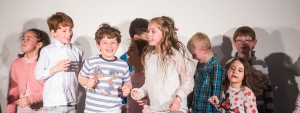 Eine Gruppe von Kindern tanzt lachend.