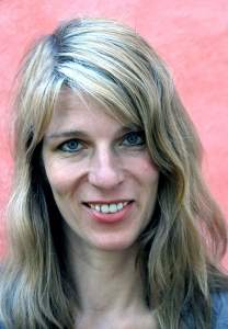 Eine Frau blickt lächelnd in die Kamera.