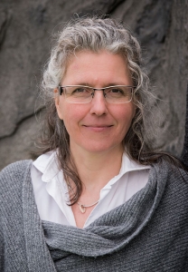 Eine Frau blickt lächelnd in die Kamera.
