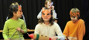 Kinder tragen selbstgebastelte Tiermasken.