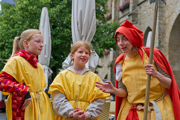 Grundschule-TPZ-Hildesheim-Hille-Huck2 Drei kostümierte Personen stehen auf dem Hildesheimer Marktplatz.