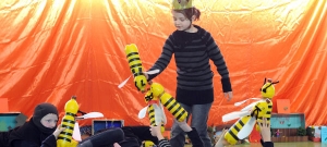 Kinder spielen mit Bienen, die sie aus Pfandflaschen selbst gebaut haben.
