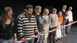 Menschen mit und ohne Behinderung stehen hinter einem Absperrband.