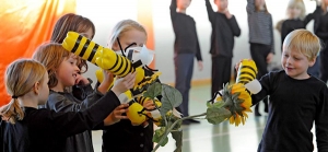 Kinder spielen mit Bienen, die sie aus Pfandflaschen selbst gebastelt haben.