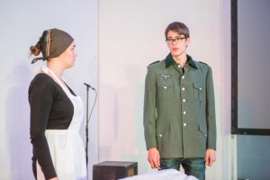 Ein junger Mann in Uniform und eine junge Frau mit bäuerlicher Kleidung stehen sich gegenüber.