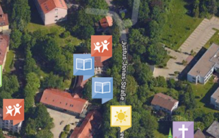 Eine Straßenkarte. Auf der Karte ist die Straße "Justus-Jonas-Straße" abgebildet. Auf der Karte sind verschiedene Symbole. Zum Beispiel ein Buch, eine Sonne, spielende Kinder.