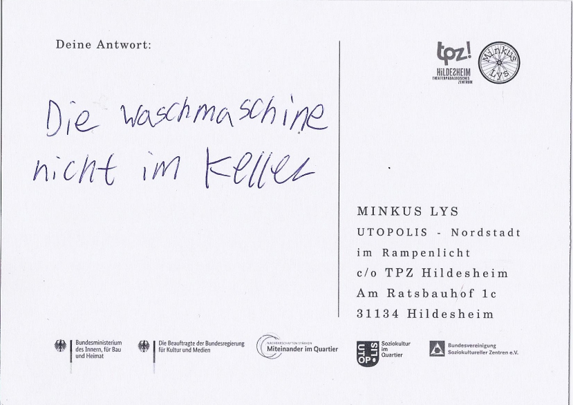 Rückseite einer Postkarte. Darauf steht: "Die Waschmaschine nicht im Keller"