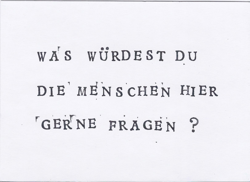 Schwarze Schrift auf weißem Hintergrund: "Was würdest du die Menschen hier gerne fragen?"