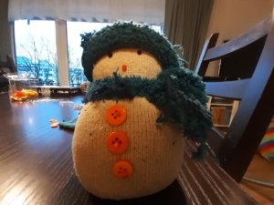 Ein Schneemann, der aus einer Socke genäht wurde.