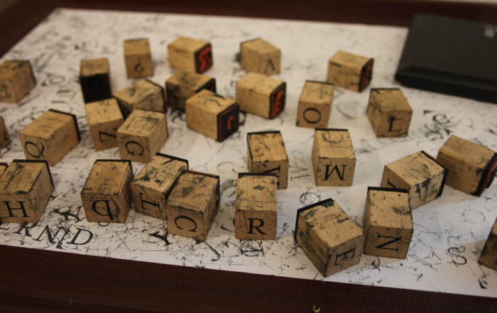 Stempel mit Buchstaben auf einem Blatt Papier.