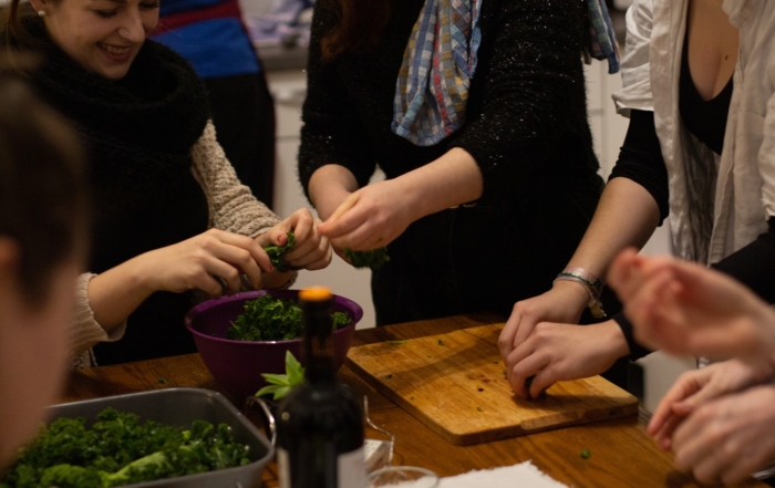 Menschen bereiten gemeinsam einen Salat zu.
