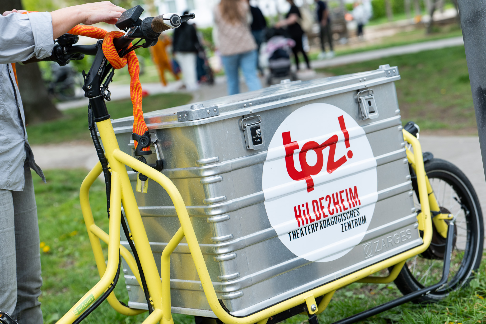 Ein Lastenfahrrad mit TPZ-Aufkleber steht auf einer Wiese.