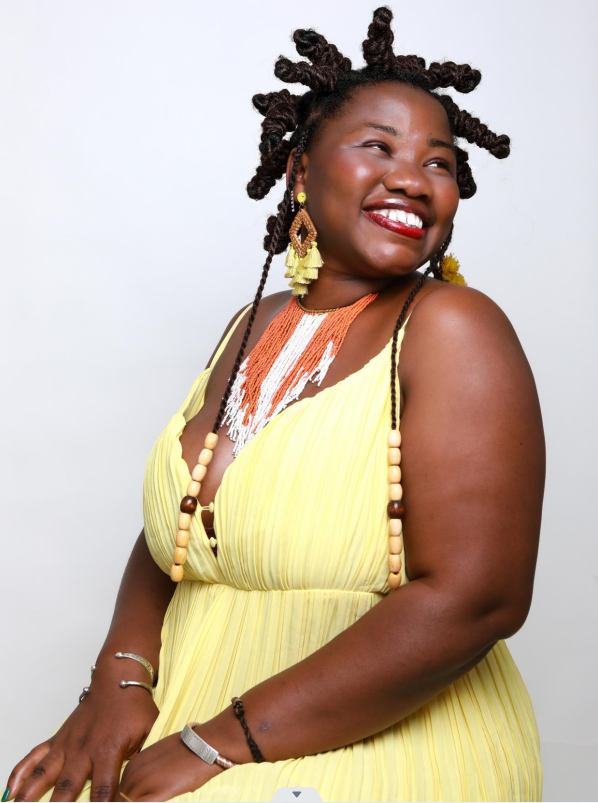 Oumou sitzt und schaut lachend zur Seite